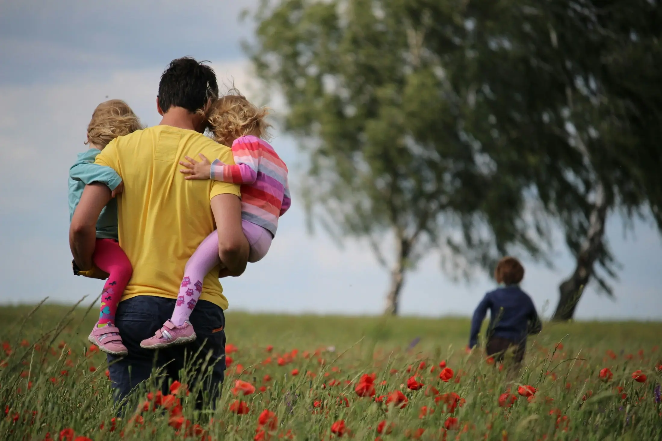 Family walking together through a sunlit field